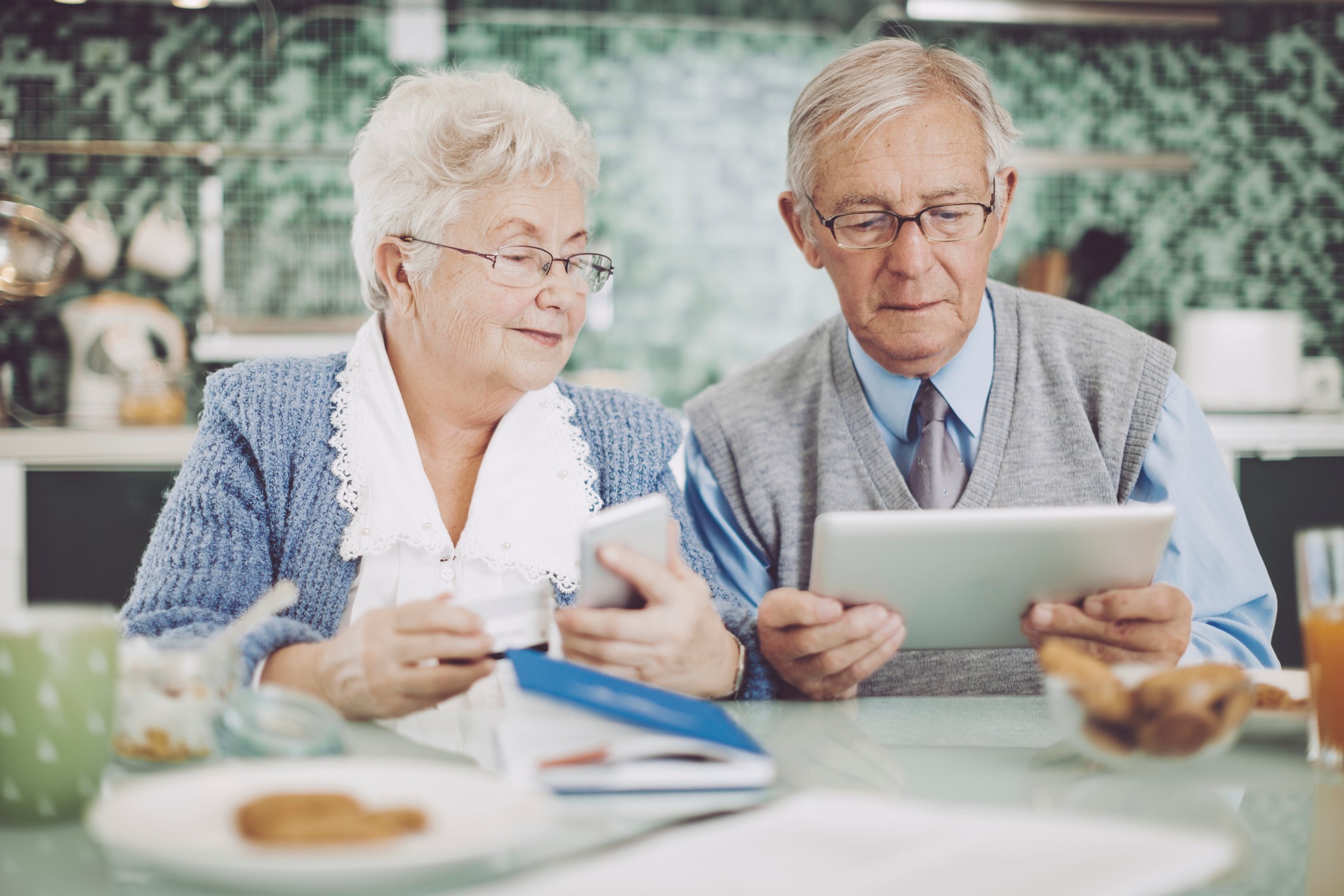 Et eldre ektepar spiser kaker mens de kikker på personvernserklæringen vår.