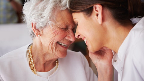 Eldre dame klemmer en yngre dame og smiler.