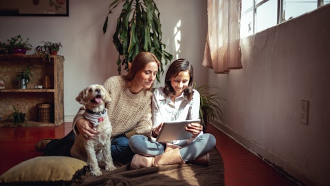 To personer som ser på en ipad med en hund.