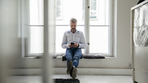 En mann sitter med mobiltelefonen.