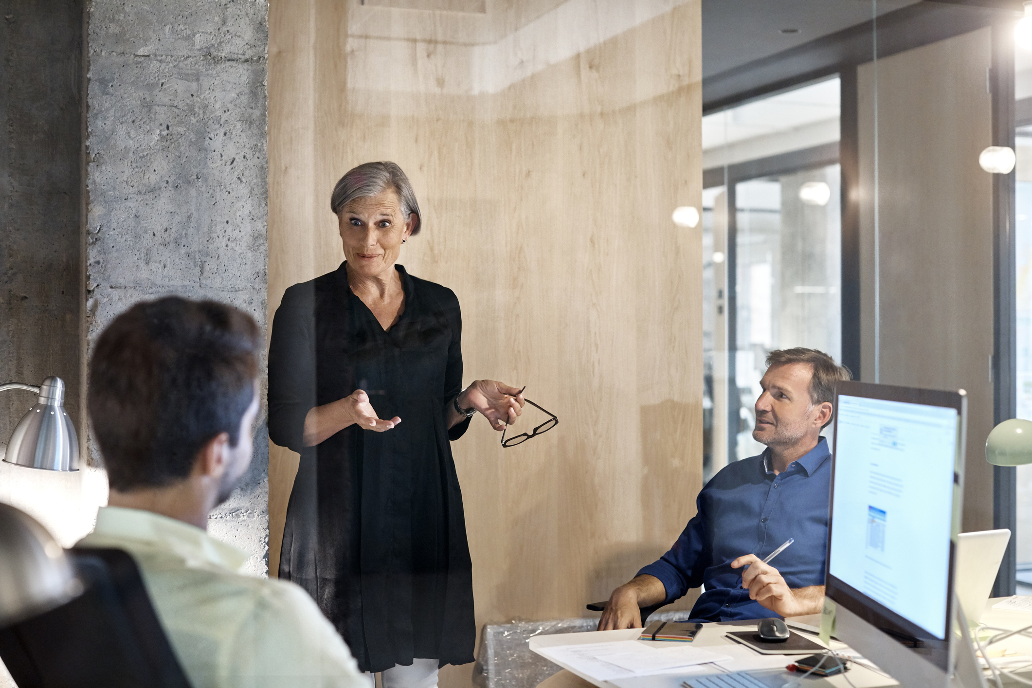 Forretningskvinne snakker med to partnere i et møte