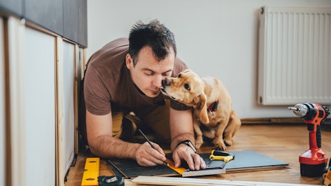 Mann og hund måler opp parkett .