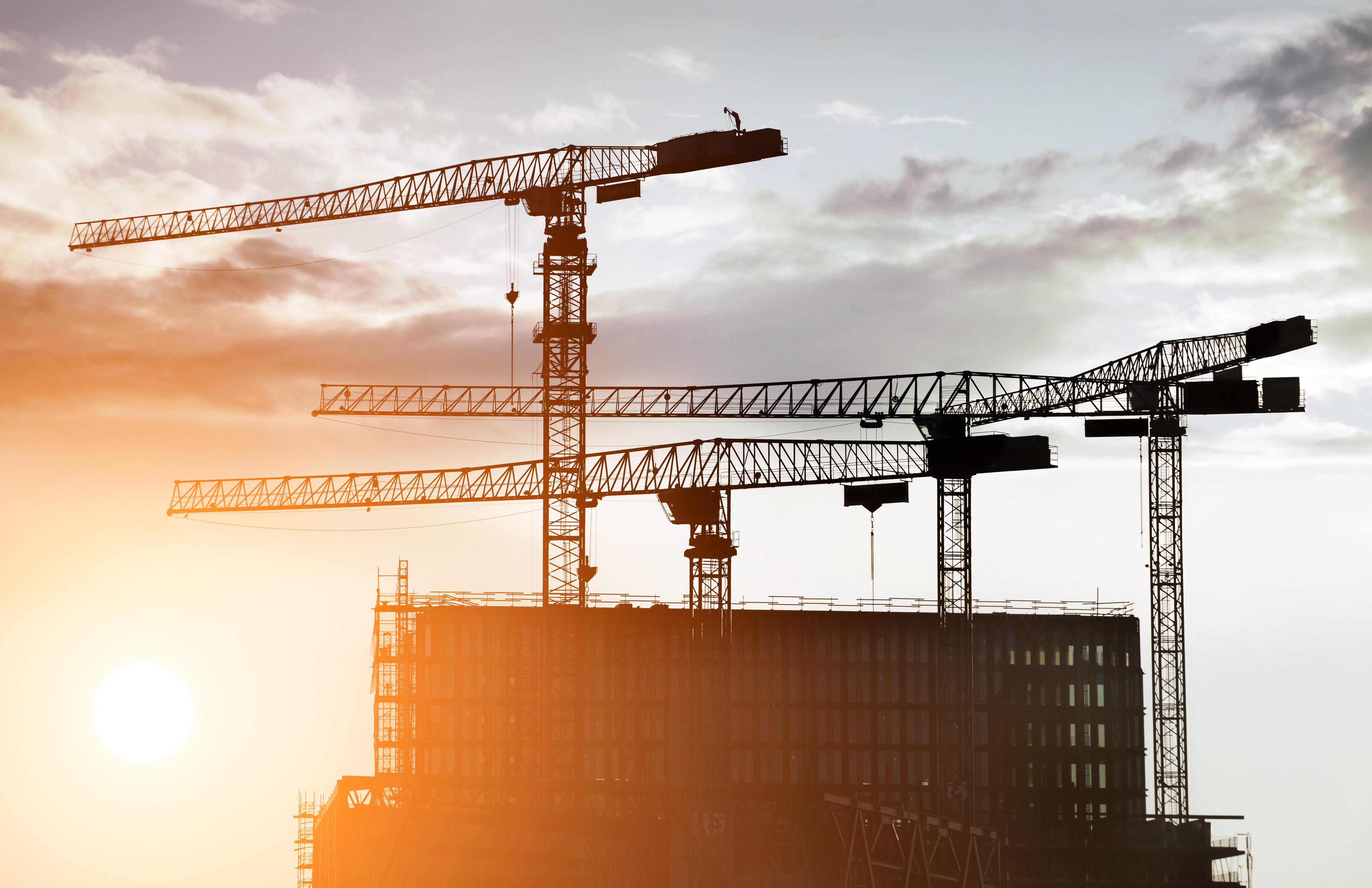 Fire heisekraner over et bygg