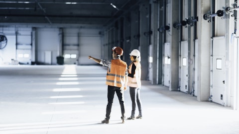 To mennesker står i et tomt lagerbygg