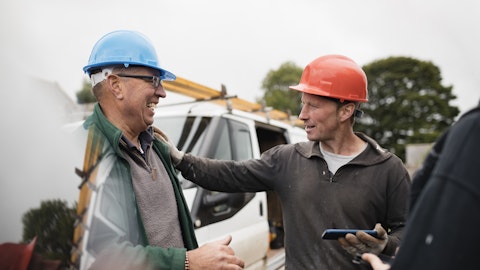 To menn prater sammen på en byggeplass