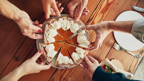 Seks personer forsyner seg av en kake.
