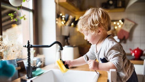 En liten gutt hjelper til med oppvasken