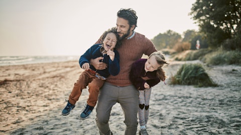 Mann med to barn på stranda