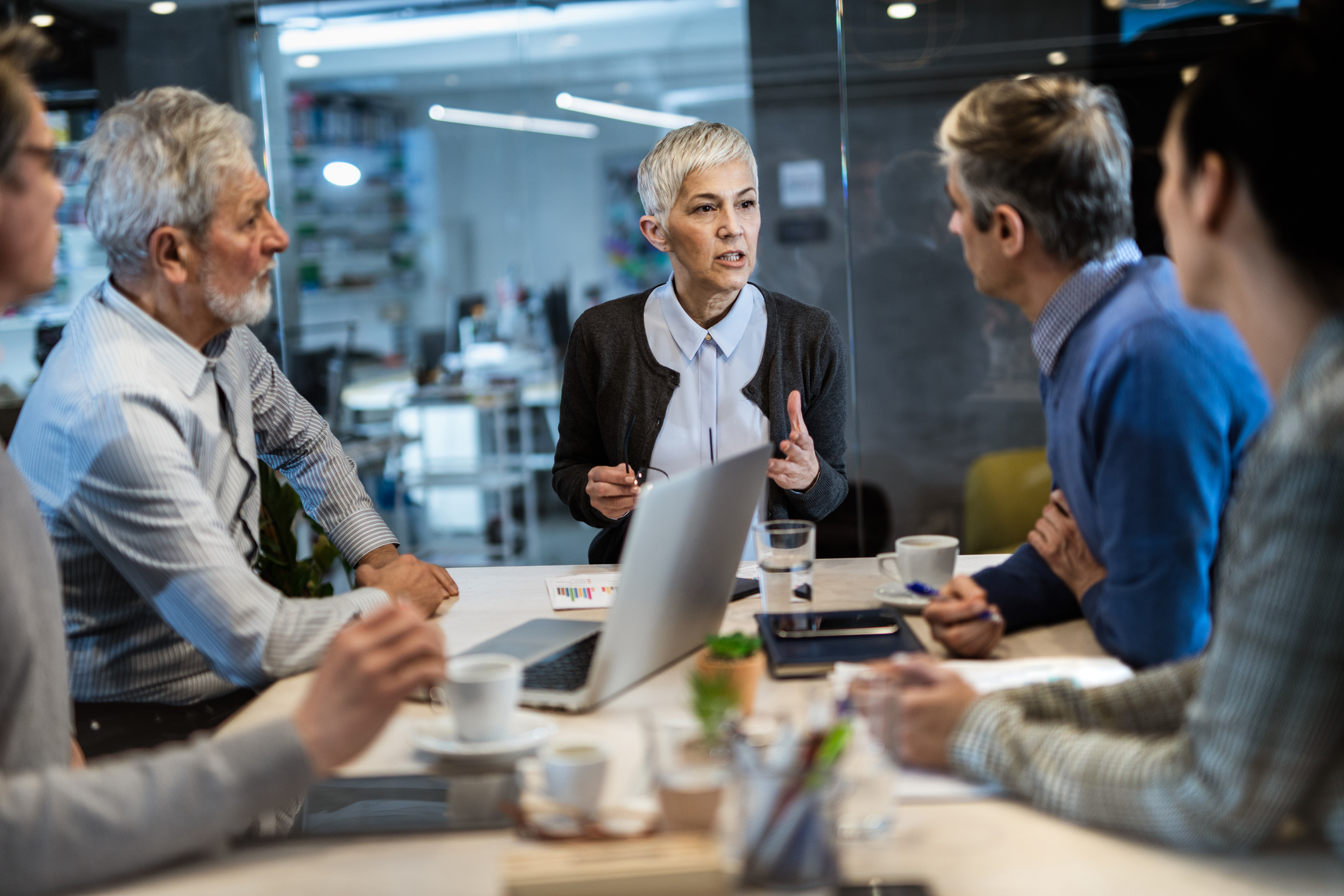 Forretningskvinne fører et møte ved et bord med medarbeidere eller klienter