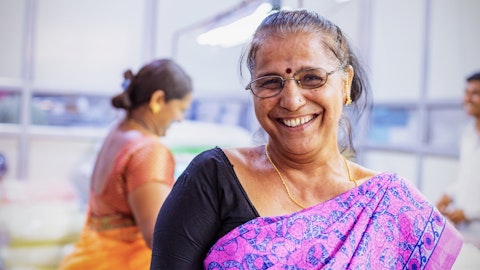En dame smiler på en fabrikk