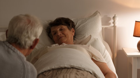 En eldre mann ser på konen sin som ligger i sengen.
