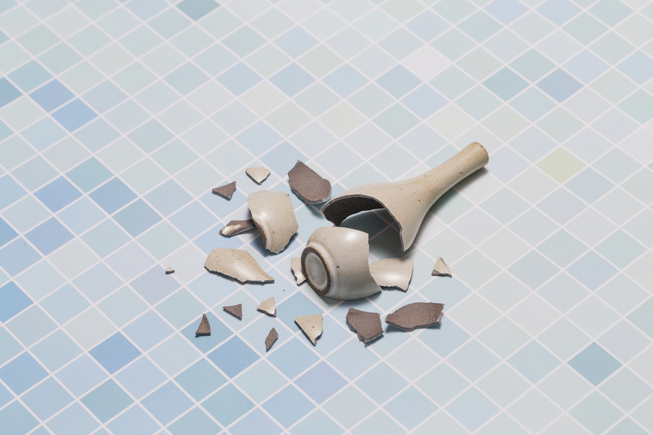 En knust vase ligger på gulvet.