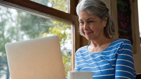 En eldre kvinne sitter på laptopen.