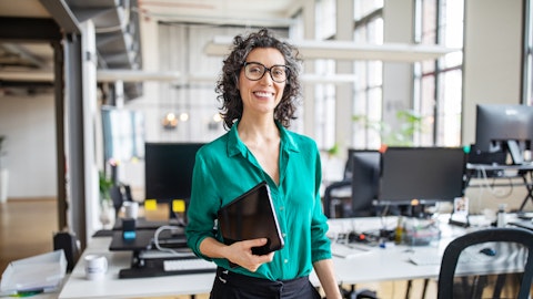 A smiling woman is standing in an office.