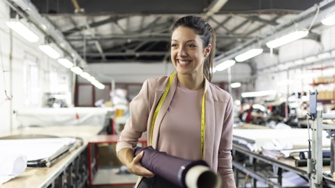 A woman standing in a fabric store.