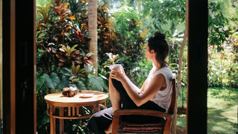 Kvinne som ser utover en grønn hage.