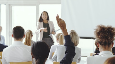 En dame står foran en klasse hvor en rekker opp hånden
