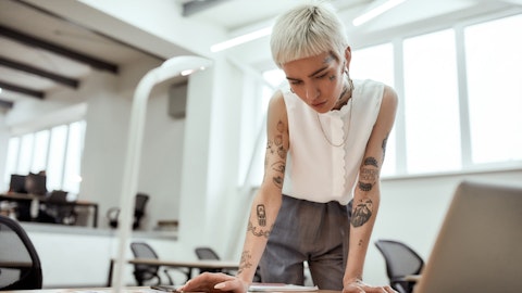 Kvinne med tatoveringer ser på noen dokumenter.