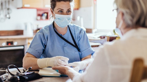 Sykepleier og pasient snakker med munnbind