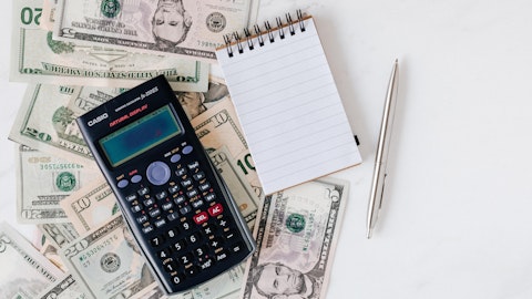Kalkulator, penger og notatblokk på bordet