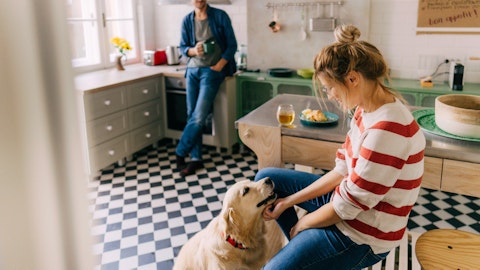 Et kjærestepar og en hund på kjøkkenet.